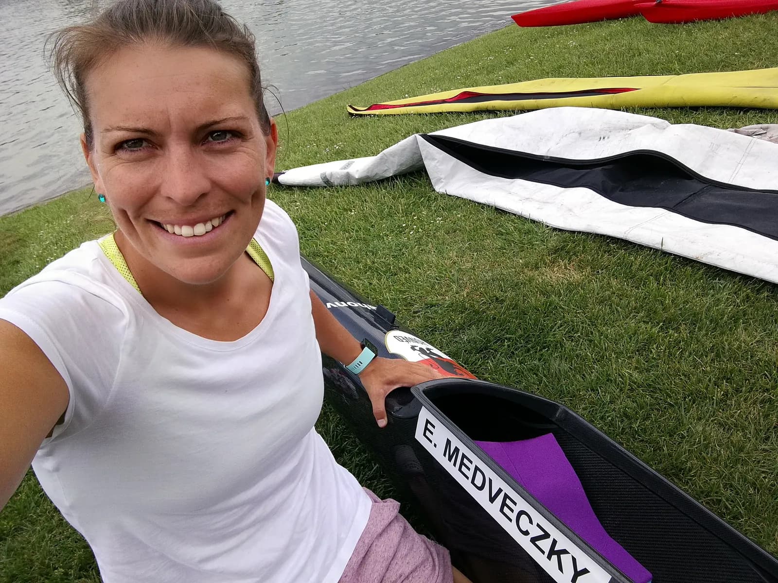 Erika Medveczky beside her kayak at the water's edge